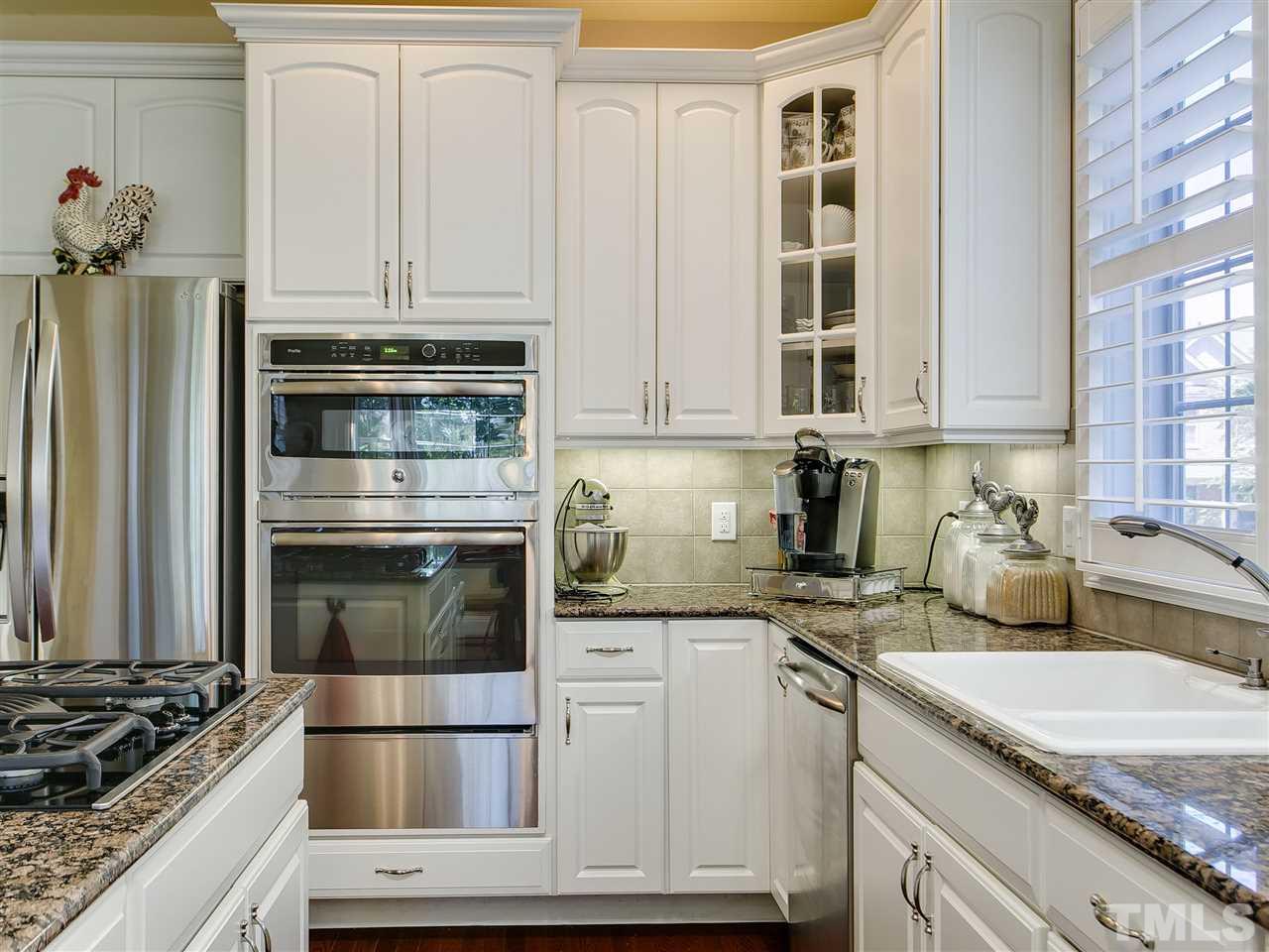 9124 Palm Bay Circle Raleigh, NC 27617 - Photo 7 of 24 a kitchen with granite countertop a stove and a refrigerator