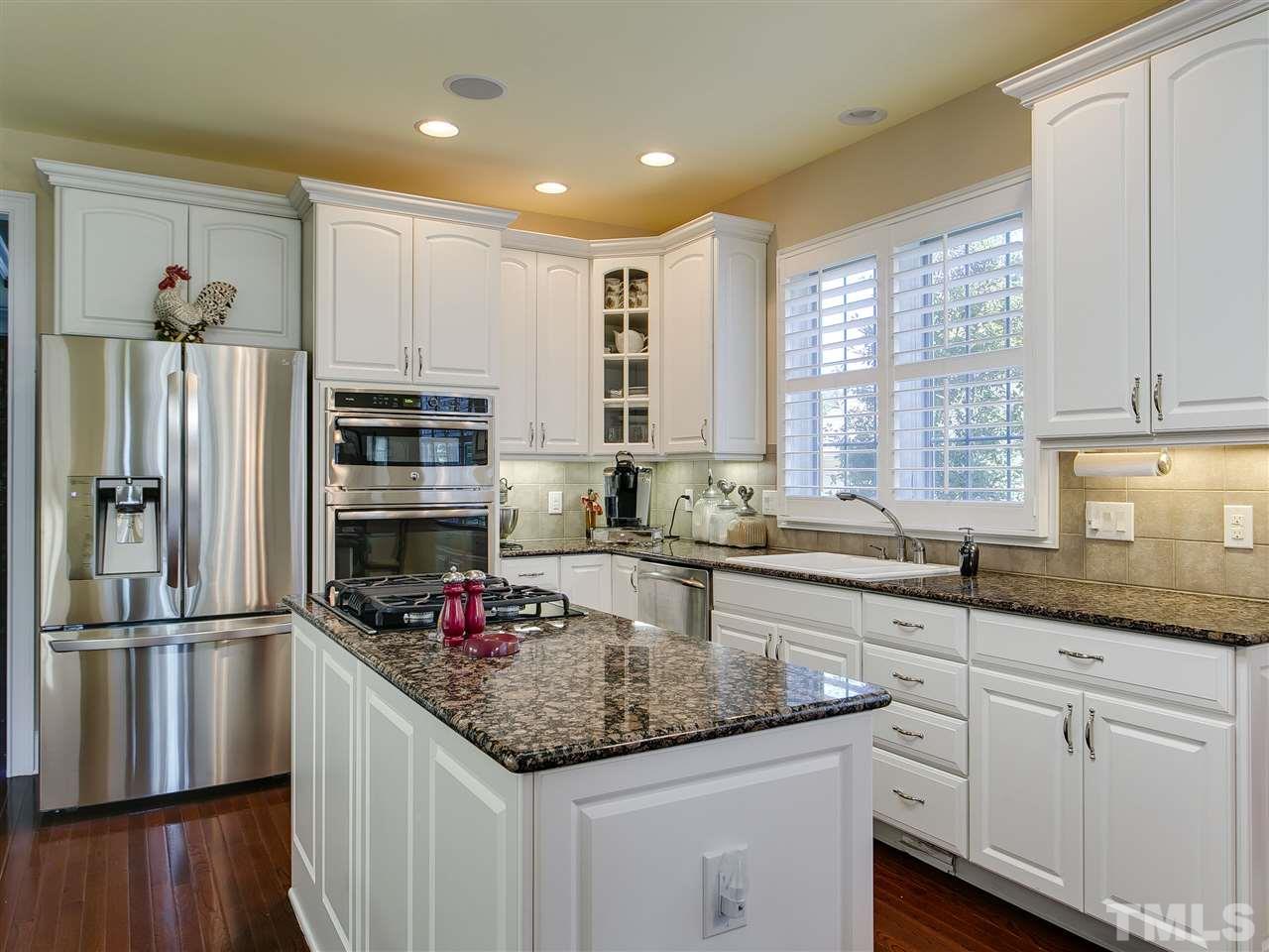 9124 Palm Bay Circle Raleigh, NC 27617 - Photo 9 of 24 a kitchen with kitchen island granite countertop a sink appliances cabinets and counter space