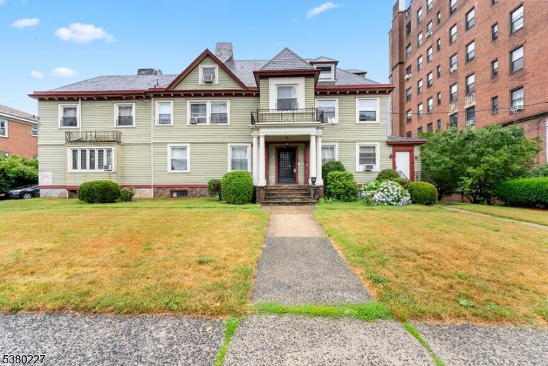 a front view of a house with yard and green space