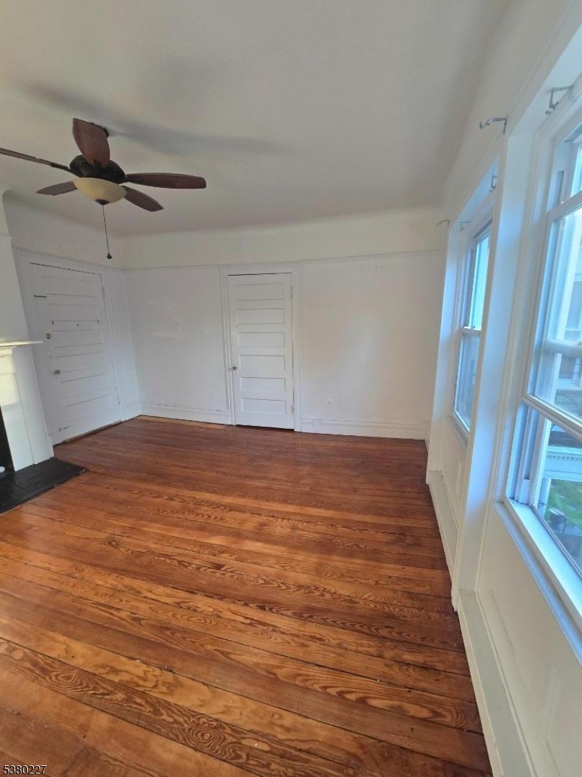 379-387 Mt Prospect Avenue, Unit 4 Newark, NJ 07104 - Photo 16 of 21 an empty room with wooden floor fan and windows