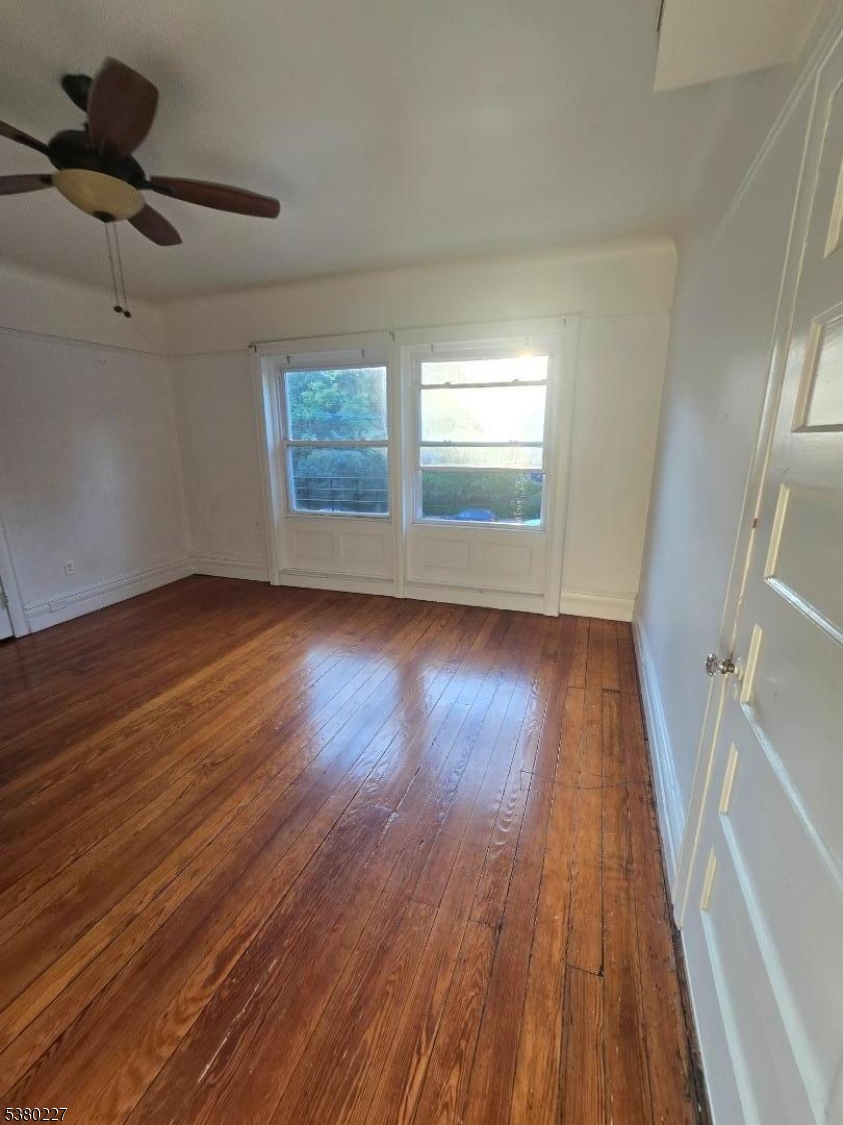 379-387 Mt Prospect Avenue, Unit 4 Newark, NJ 07104 - Photo 18 of 21 a view of an empty room with wooden floor and a window