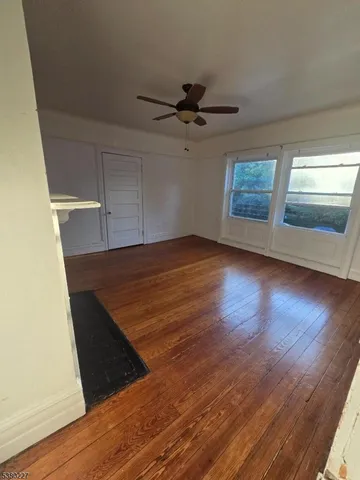 a view of empty room with wooden floor and fireplace