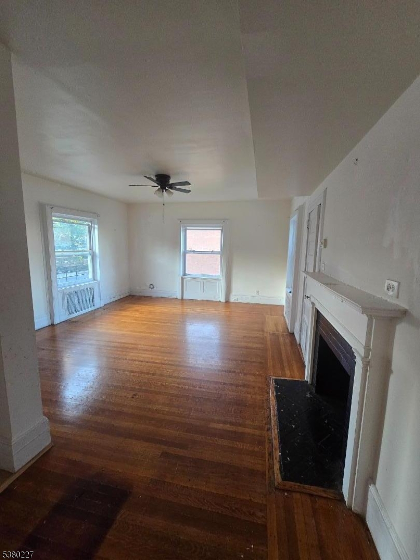 379-387 Mt Prospect Avenue, Unit 4 Newark, NJ 07104 - Photo 5 of 21 a view of an empty room with wooden floor fireplace and a window