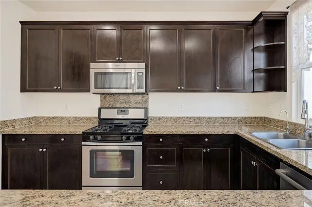 a kitchen with granite countertop a stove and cabinets