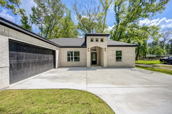 a view of a white house with a yard and garage