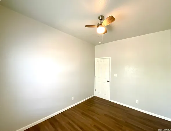 an empty room with a window and a ceiling fan