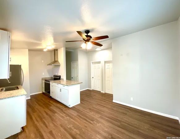 a white kitchen with a stove a sink and a refrigerator
