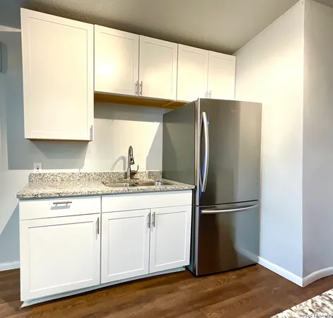 a kitchen with appliances cabinets and a wooden floor