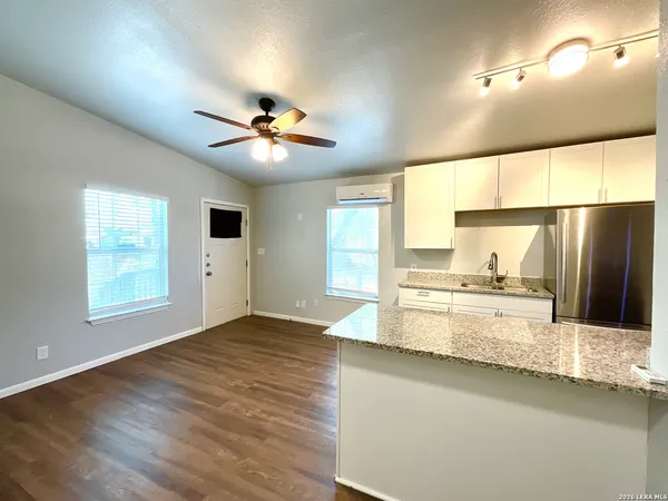 a large kitchen with stainless steel appliances a large window a sink and a refrigerator