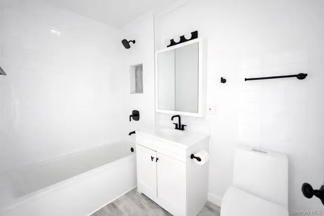 a bathroom with a bathtub sink vanity and mirror