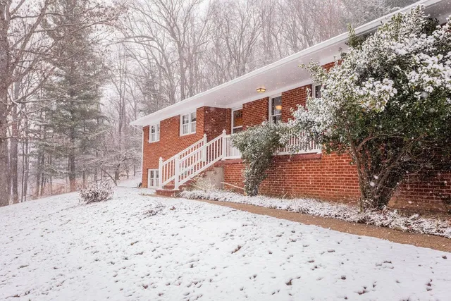 a pathway of a house with a yard covered in snow
