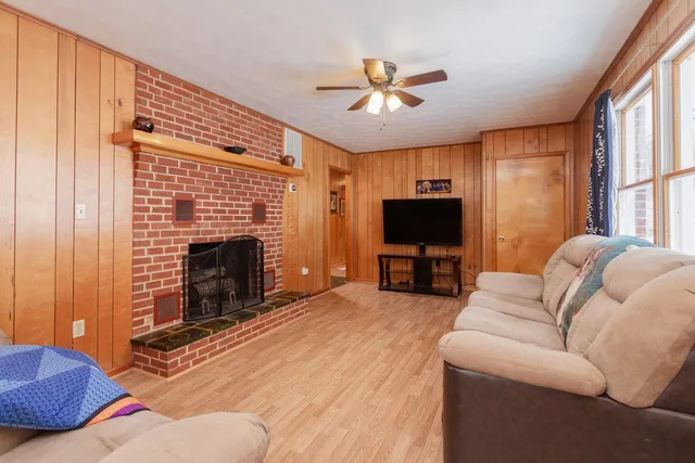 a living room with furniture a flat screen tv and a fireplace