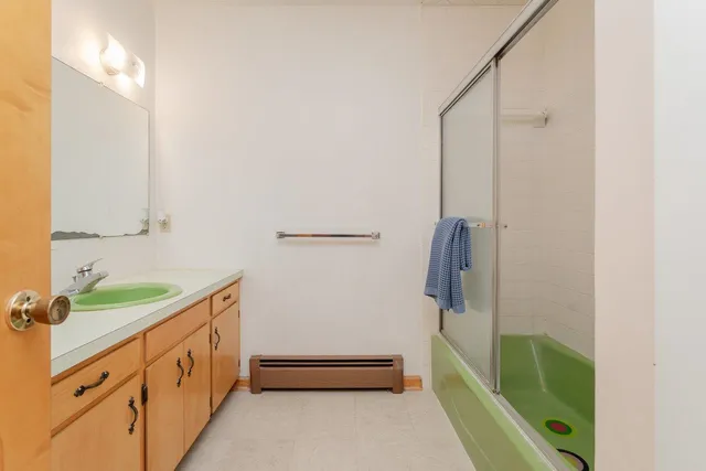 a bathroom with a double vanity sink toilet and shower