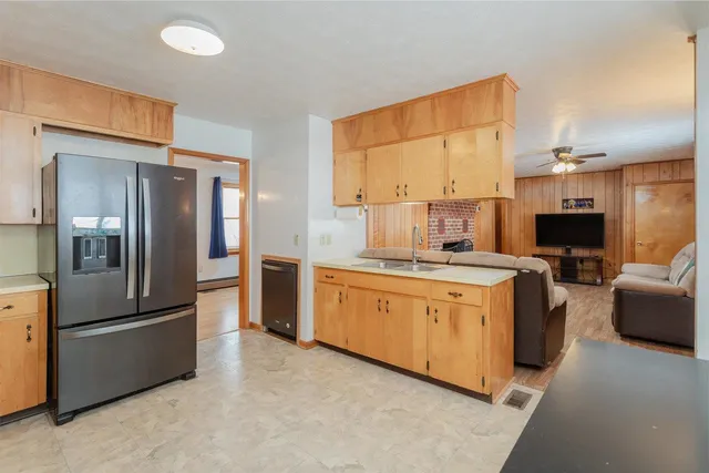 a kitchen with stainless steel appliances kitchen island granite countertop a refrigerator a stove top oven a sink and dishwasher