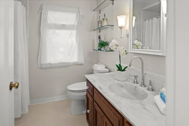 a bathroom with a toilet a sink and a mirror
