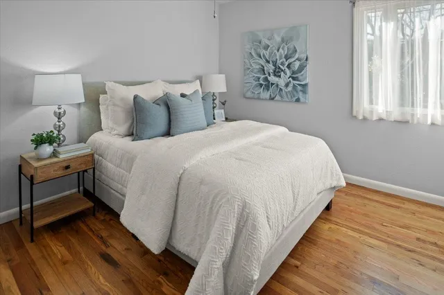 a large bed sitting in a bedroom with a lamp and a mirror