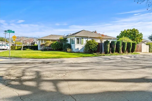 a view of a house with a big yard and large trees