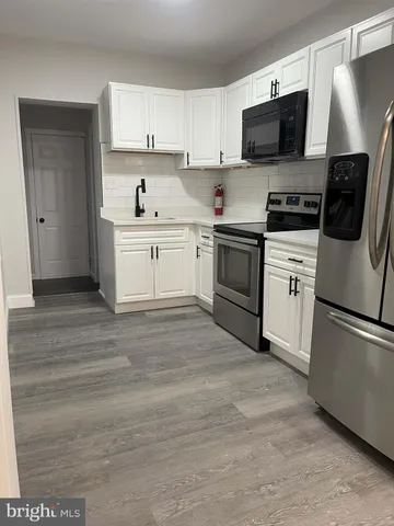a kitchen with a sink and steel appliances
