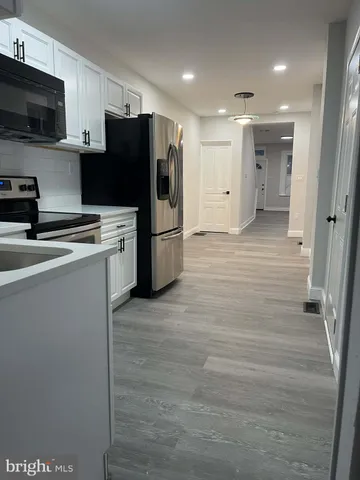 a kitchen with stainless steel appliances a refrigerator a stove top oven a sink and dishwasher