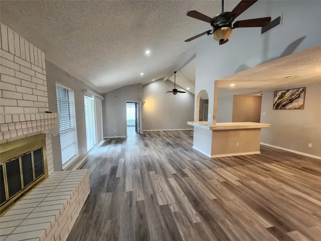 a view of a livingroom with wooden floor and a ceiling fan