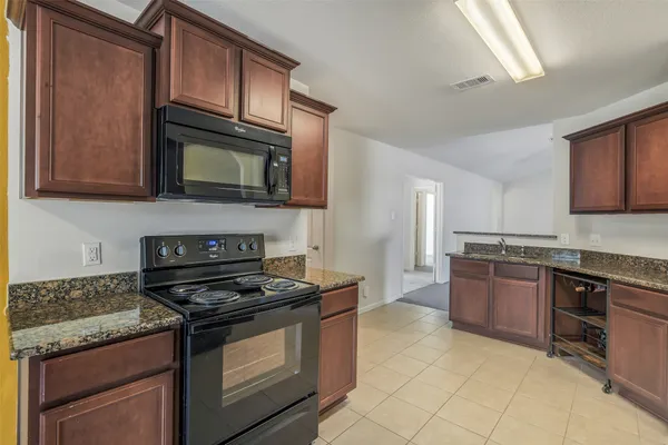 a kitchen with stainless steel appliances granite countertop a refrigerator sink and stove