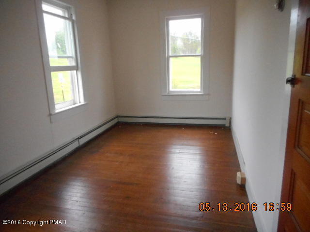 233 Perkins Pond Road Beach Lake, PA 18405 - Photo 5 of 20 an empty room with wooden floor and windows