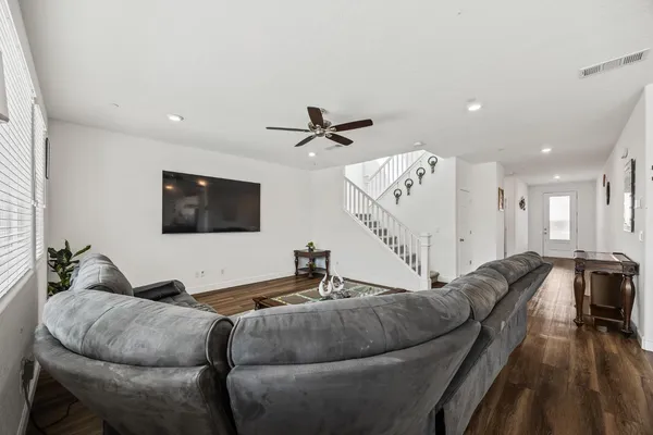a living room with furniture and a wooden floor