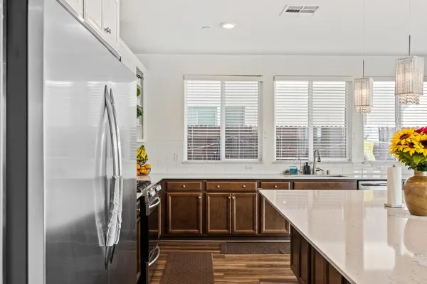 a kitchen with stainless steel appliances granite countertop a refrigerator and a sink