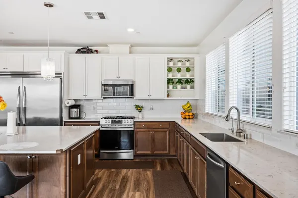 a kitchen with stainless steel appliances granite countertop a sink stove cabinets and refrigerator