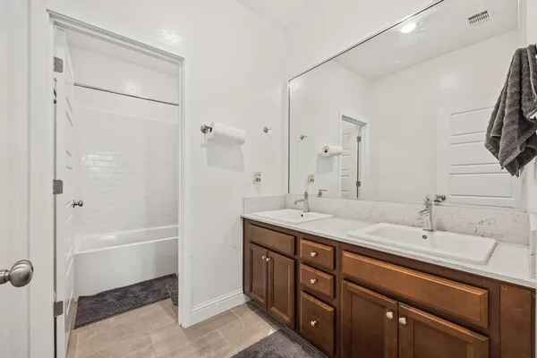 a bathroom with a double vanity sink mirror and shower