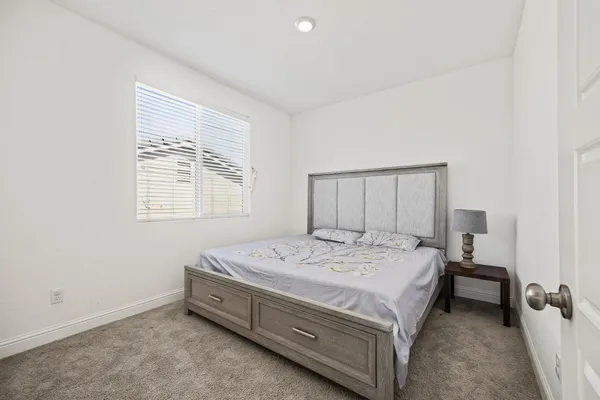 a bed sitting in a bedroom next to a window