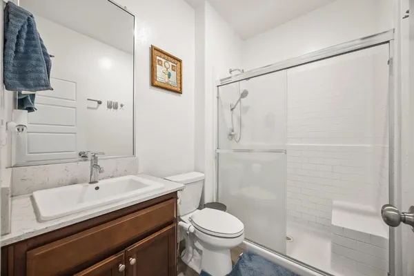 a bathroom with a sink a toilet and shower
