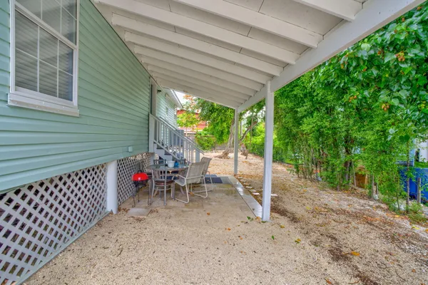 a backyard of a house with table and chairs