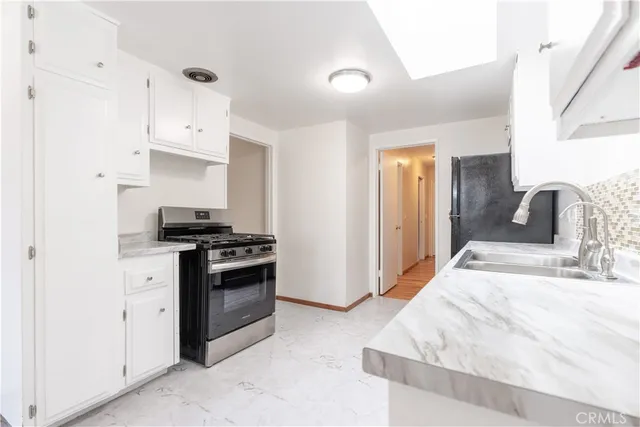 a kitchen with stainless steel appliances kitchen island a sink stove and cabinets