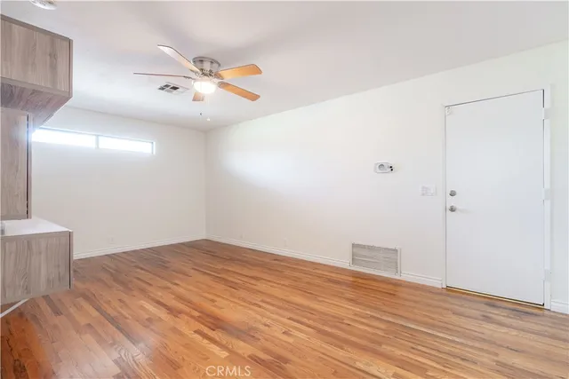 a view of empty room with wooden floor