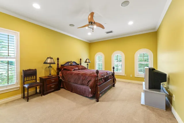 a spacious bedroom with a bed and a chandelier