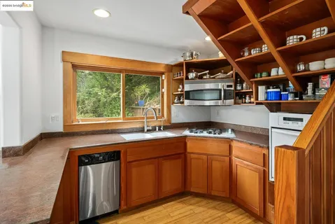 a kitchen with stainless steel appliances granite countertop a sink a stove and cabinets