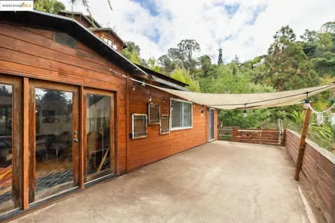 a view of deck with furniture and trees