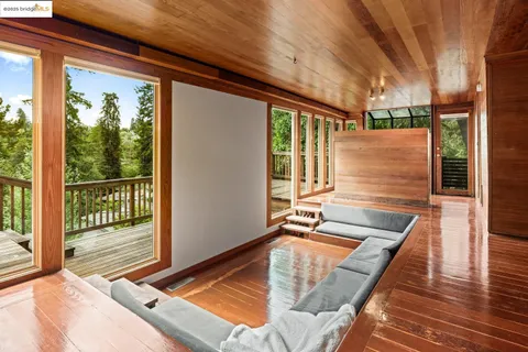 a view of an empty room with wooden floor and iron fence