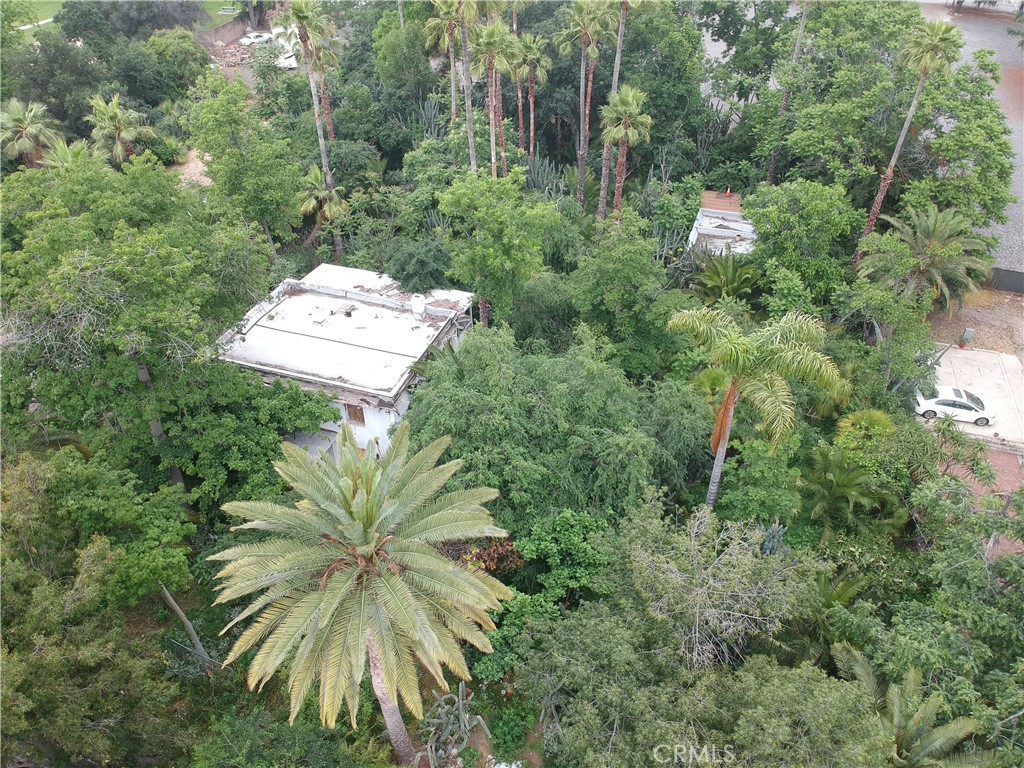 an aerial view of residential house with outdoor space and trees all around