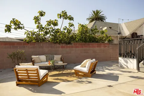 a view of a patio with couple of chairs and a fountain