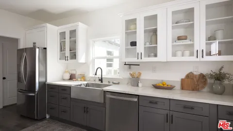 a kitchen with stainless steel appliances a sink a refrigerator and cabinets