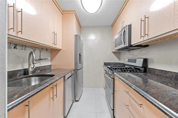 a kitchen with granite countertop a sink a stove and cabinets