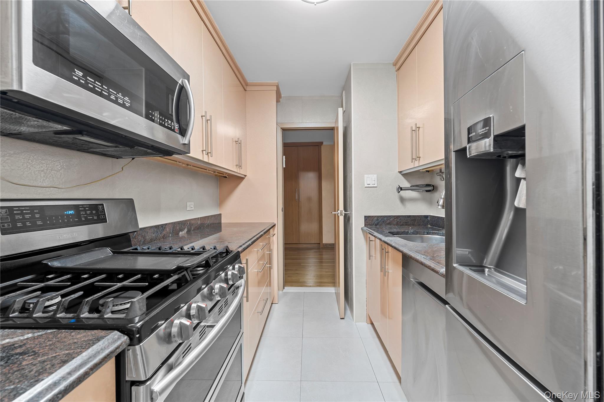 102-10 66th Road, Unit 3B Queens, NY 11375 - Photo 15 of 26 a kitchen with stainless steel appliances granite countertop a stove and a refrigerator