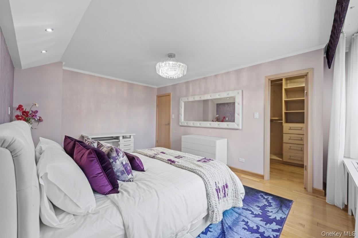 102-10 66th Road, Unit 3B Queens, NY 11375 - Photo 5 of 26 a bedroom with a bed and a chandelier