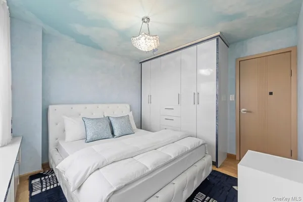 a bedroom with a bed and a chandelier