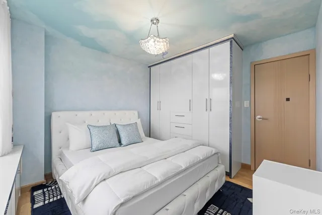 a bedroom with a bed and a chandelier