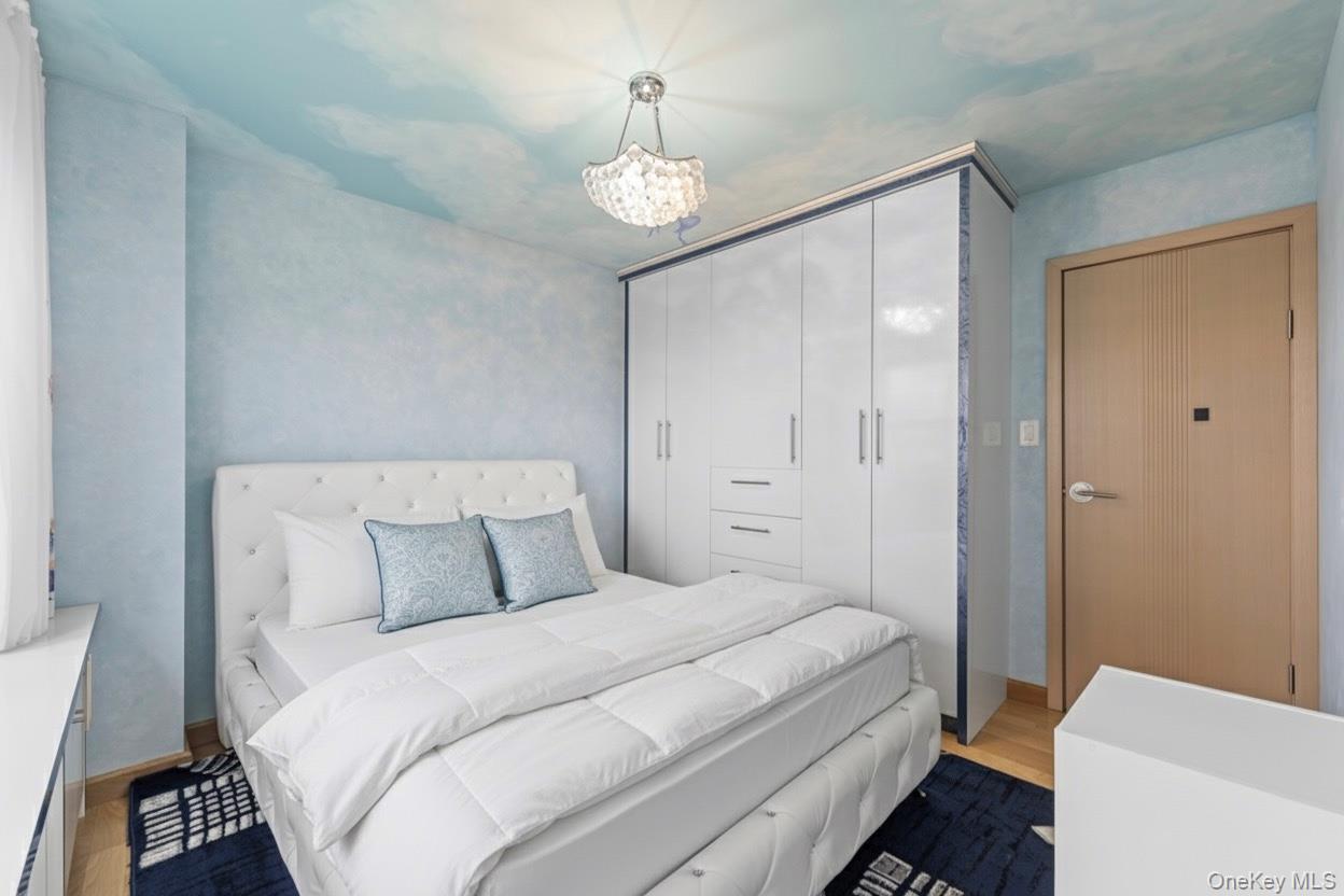 102-10 66th Road, Unit 3B Queens, NY 11375 - Photo 8 of 26 a bedroom with a bed and a chandelier