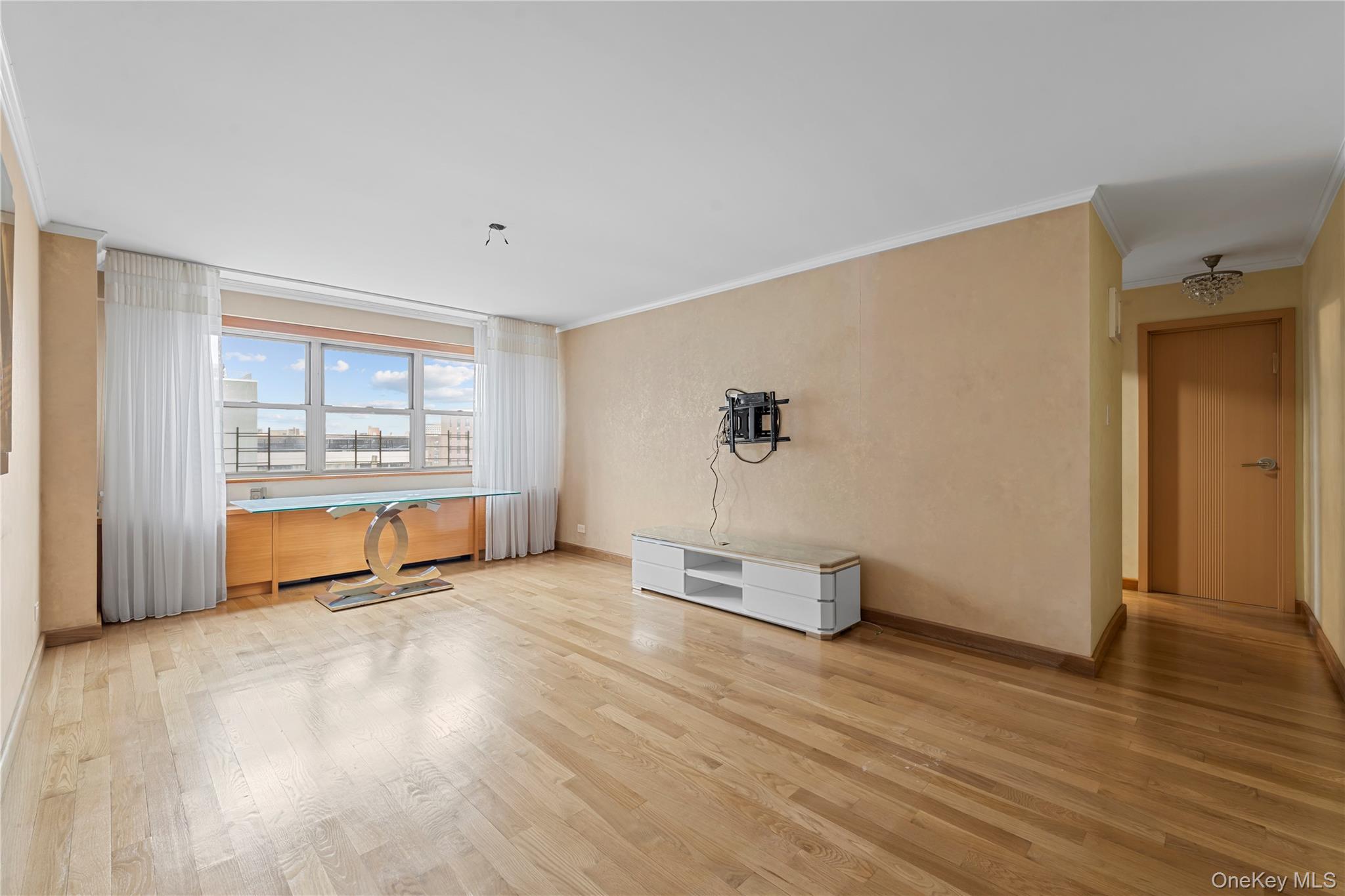 102-10 66th Road, Unit 3B Queens, NY 11375 - Photo 9 of 26 an empty room with wooden floor and windows