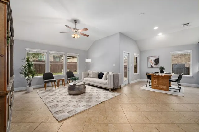 a living room with furniture a large window and chandelier